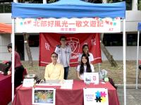 Three College student ambassadors and a sugar painting artist at the College game booth at the University Mall